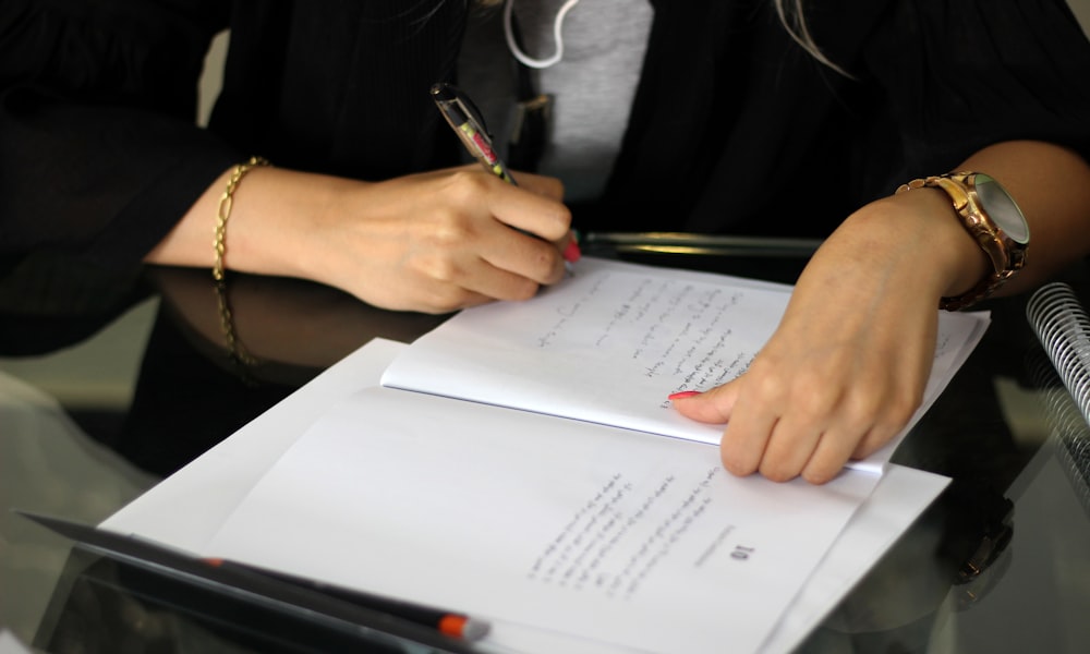 a person writing on a piece of paper