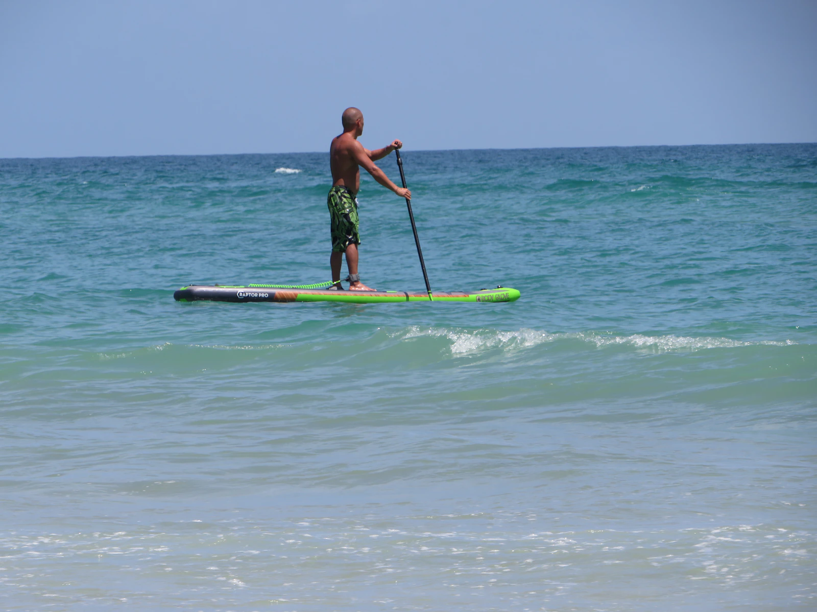 Paddleboarder moving across open ocean water