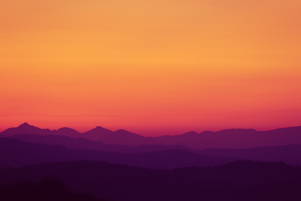 a sunset over a mountain range