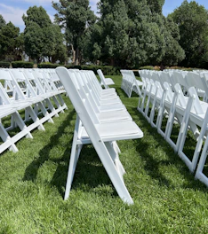 A neat row of sleek foldable chairs set up outdoors in Riyadh under a clear sky.