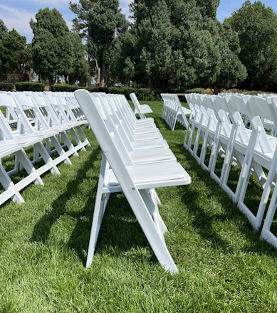 A neat row of sleek foldable chairs set up outdoors in Riyadh under a clear sky.