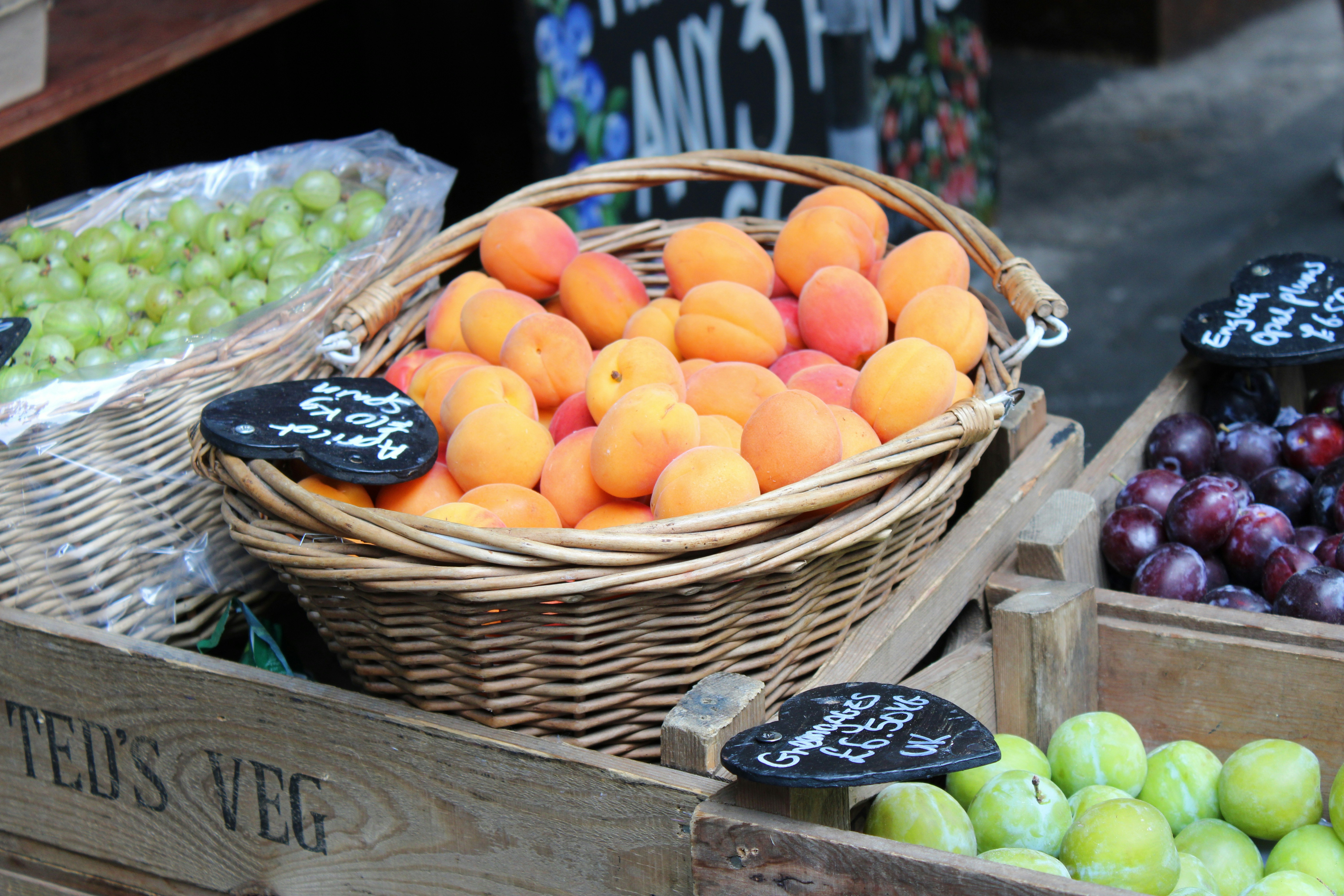 Basket of apricots beside grapes