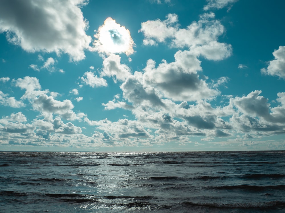 a body of water with clouds above it