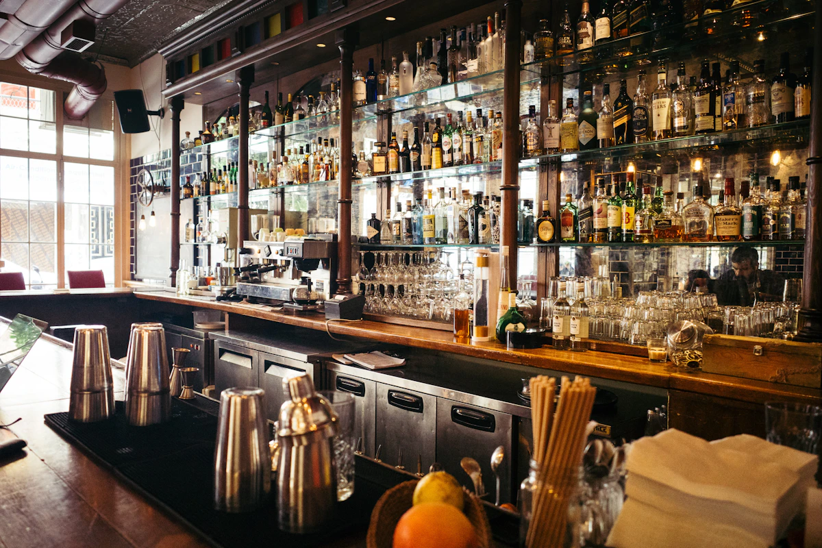 A backlit bar shelf lined with spirit bottles