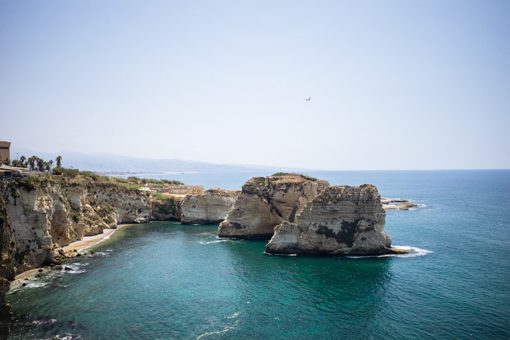 a rocky cliff next to a body of water