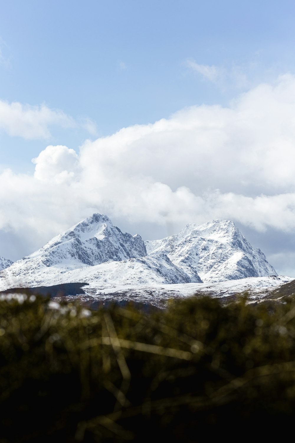 a snowy mountain with clouds