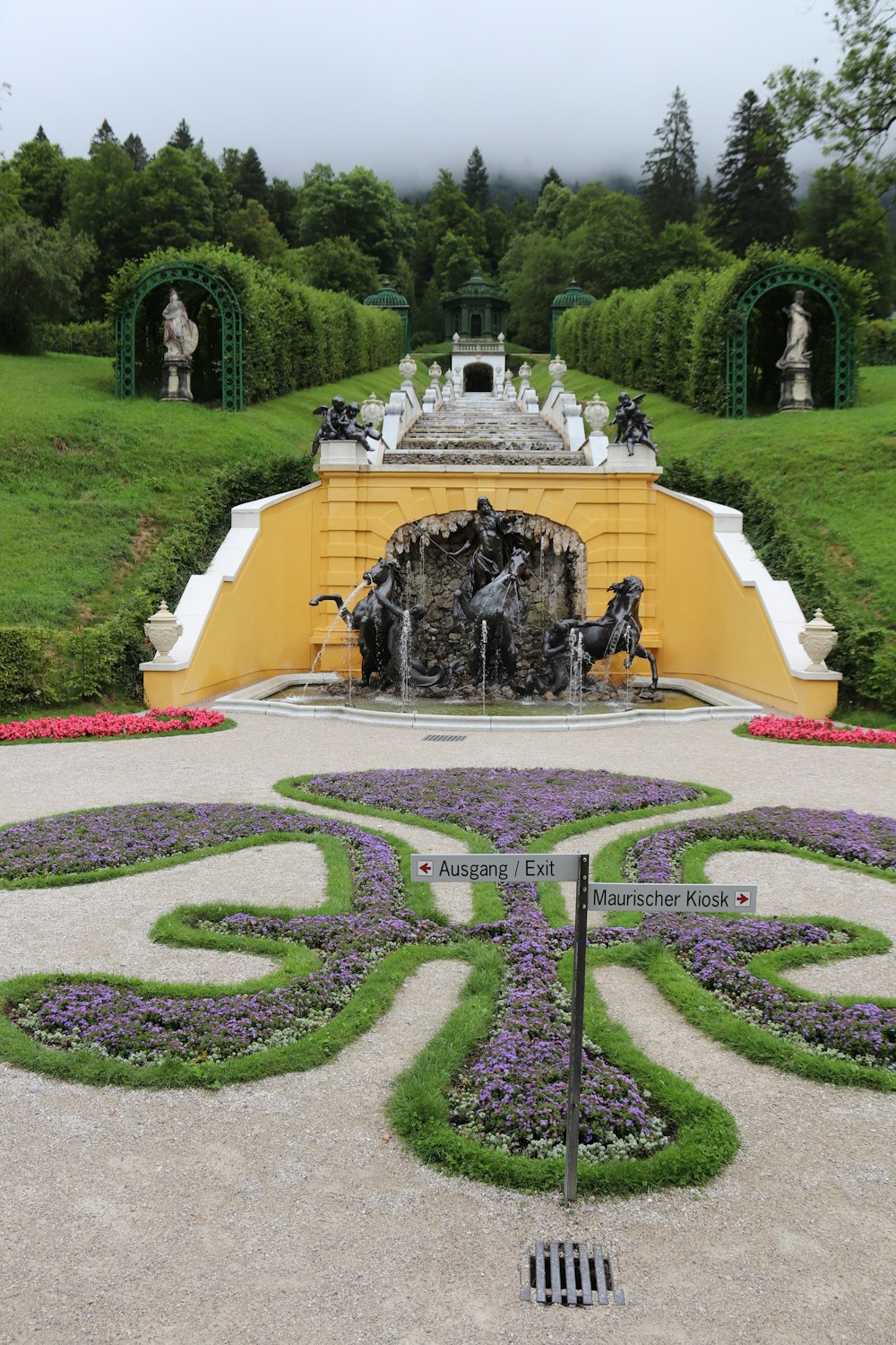 a large yellow fountain in a garden