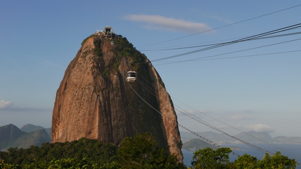 a car driving on a cliff with Sugarloaf Mountain in the background