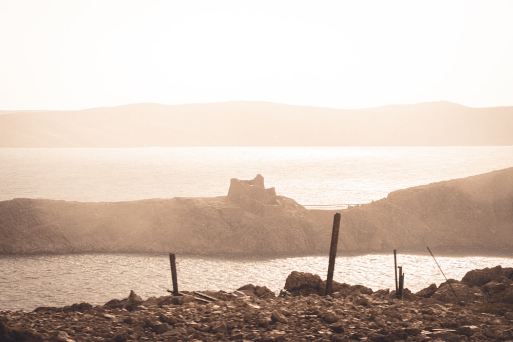 a rocky beach with a large body of water in the background