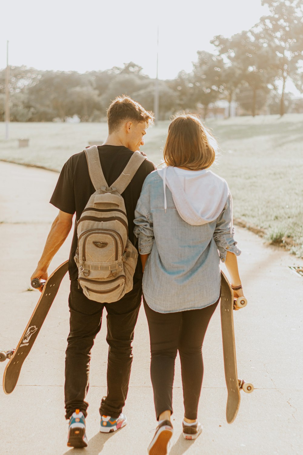 a man and a woman holding skateboards