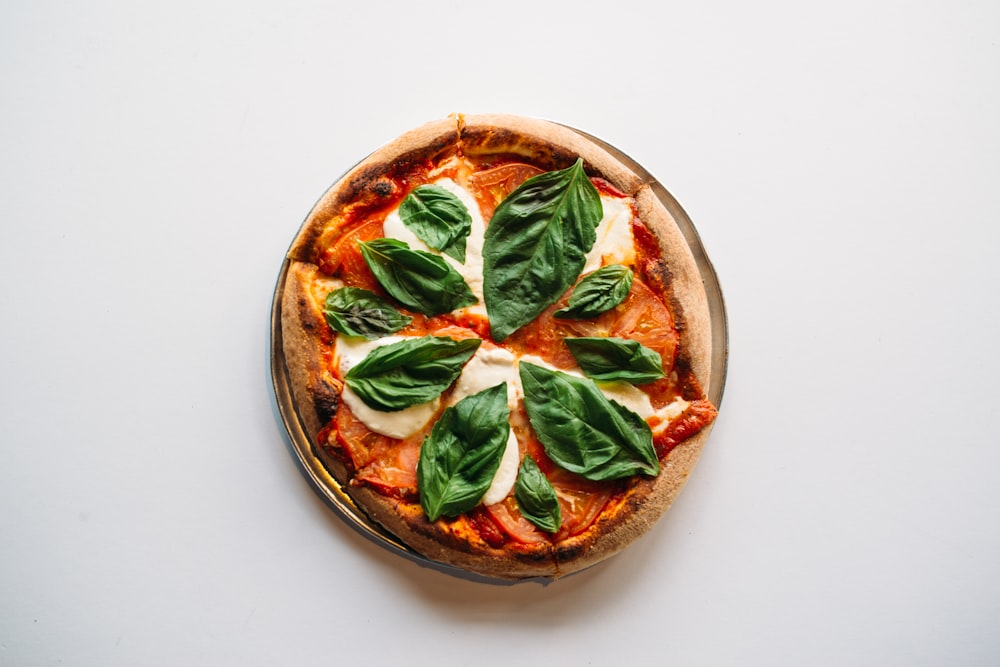 a pizza with basil on top