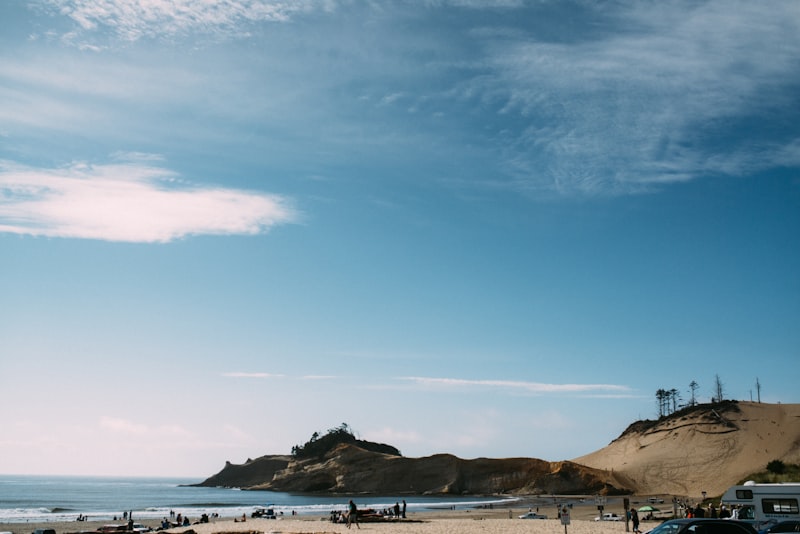 a beach with people and a hill in the background