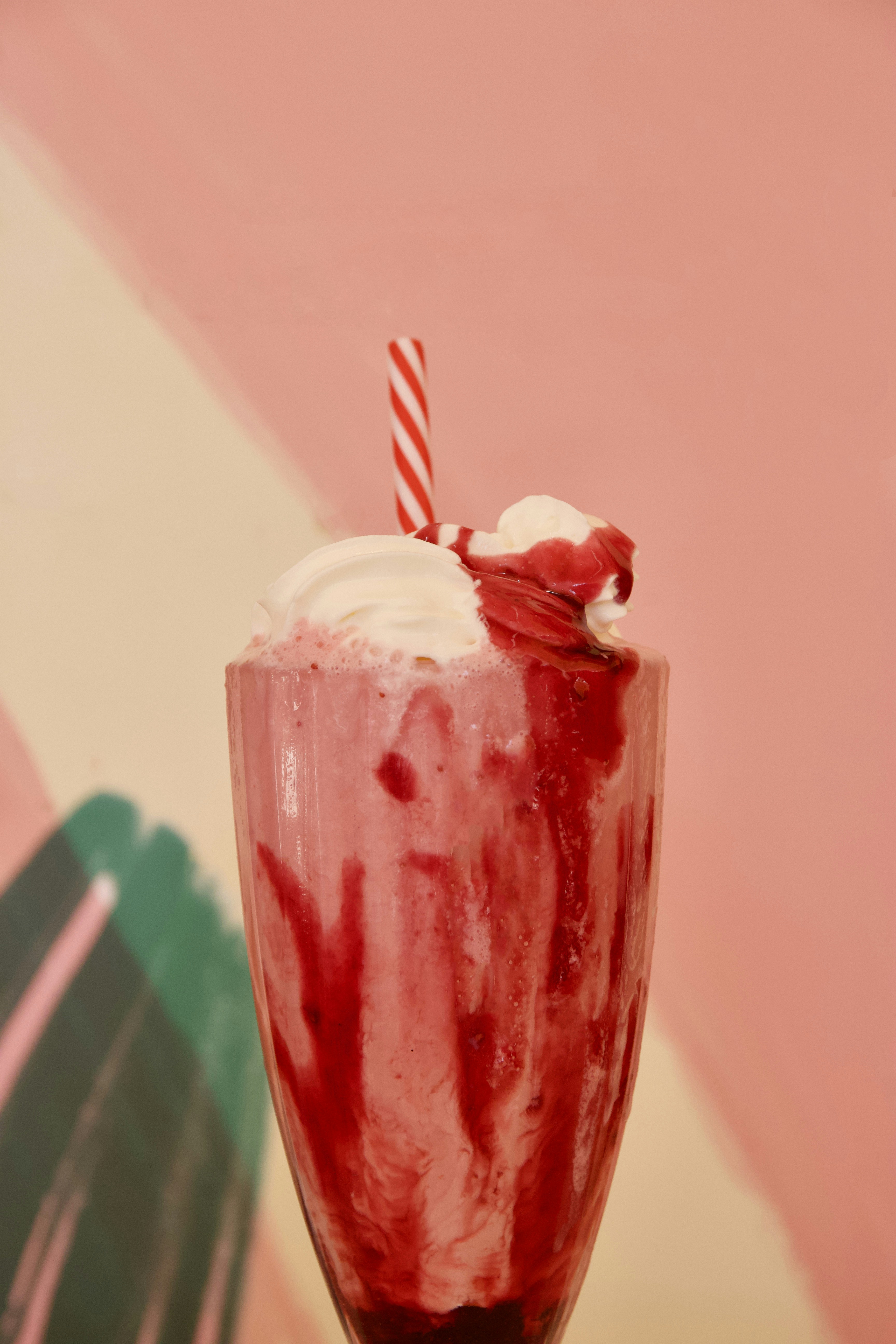 Malteada rosa de fresa con crema batida en vaso alto