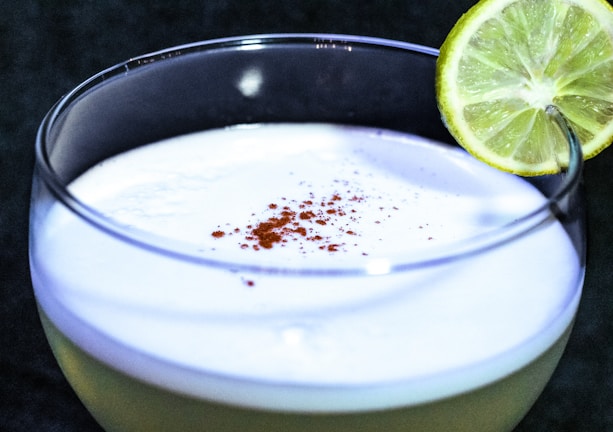 Close-up shot of a refreshing mango lassi in a traditional glass with a sprinkle of cardamom on top.