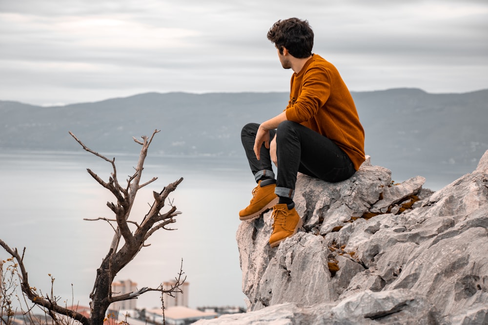 Un uomo seduto su una roccia