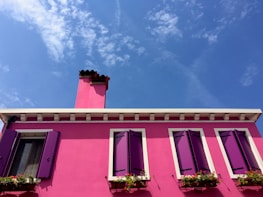 A vibrant painted house standing strong under a bright blue Florida sky.