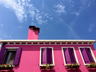 A vibrant, freshly painted house exterior showcasing a mix of bold and subtle colors under a clear sky.