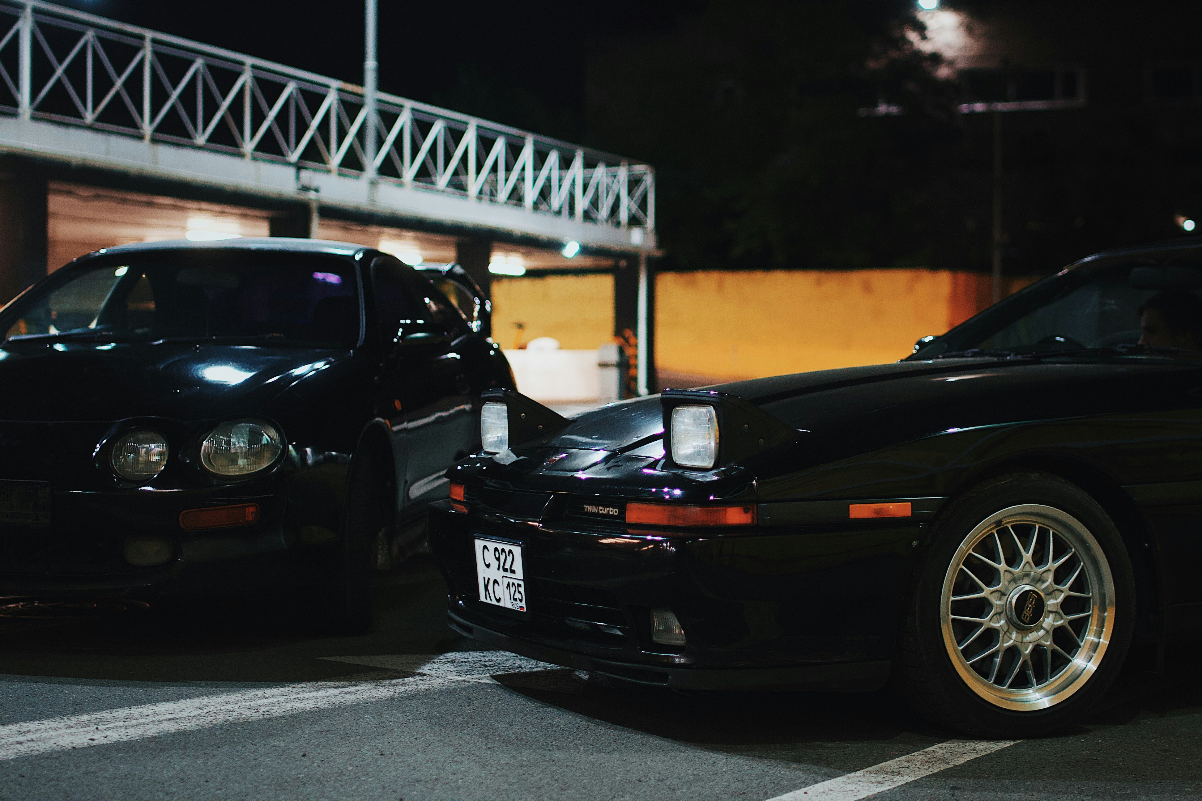a couple of cars parked in a parking lot at night