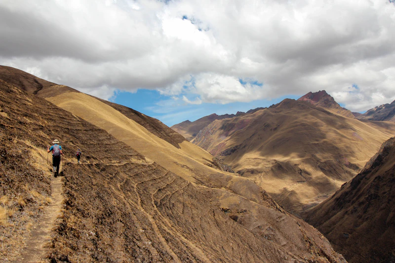 A group of trekkers hiking up a bare Andean mountainside in Peru