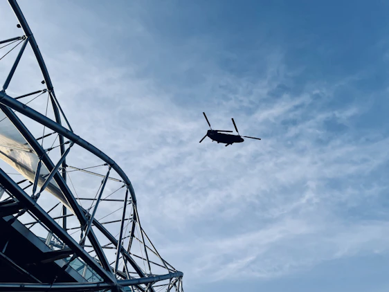 A professional engineer inspecting a modern helipad under construction with clear skies in the background.