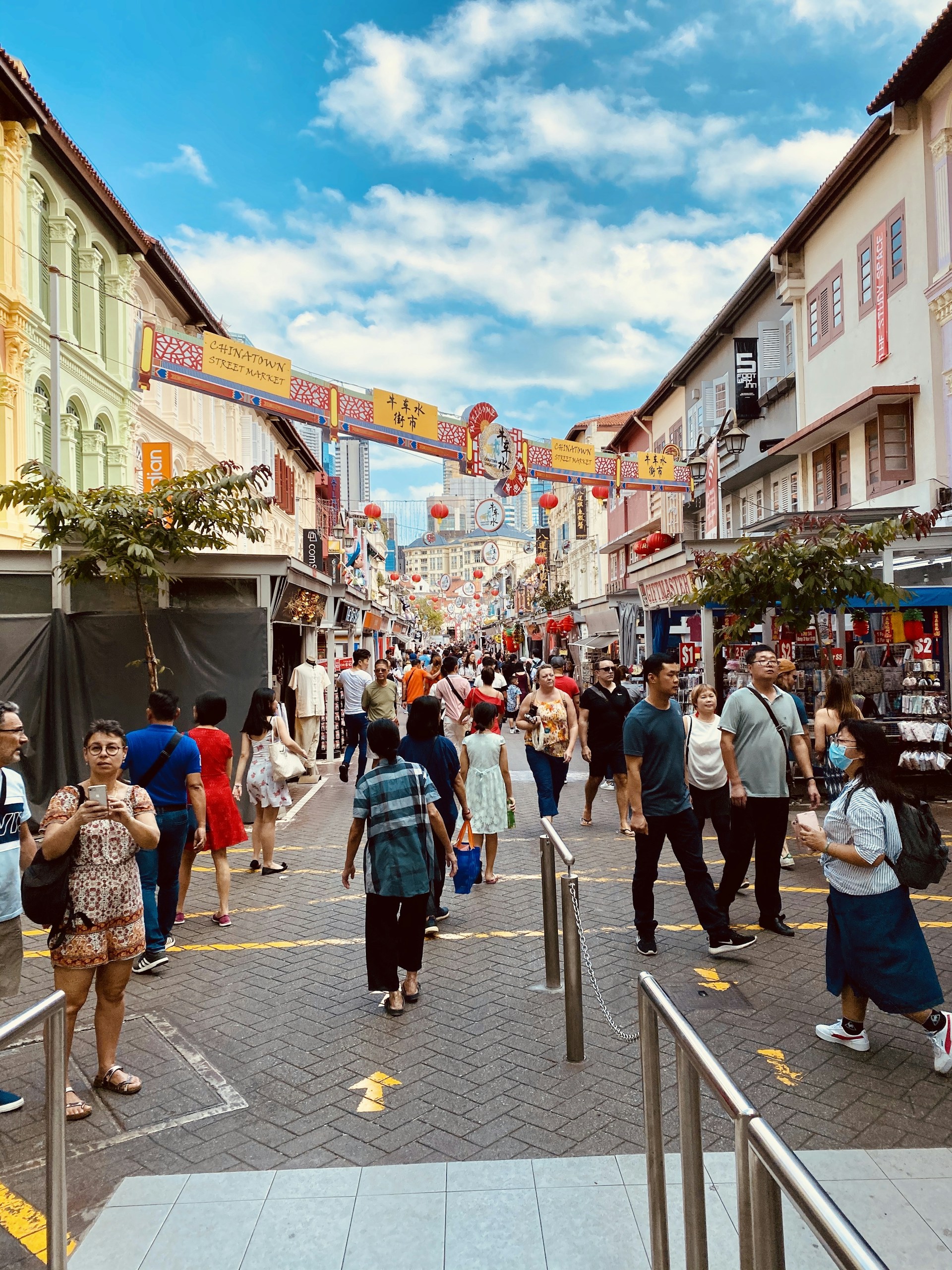 A bustling street market filled with colorful stalls and smiling faces, showcasing the lively spirit of a distant city.