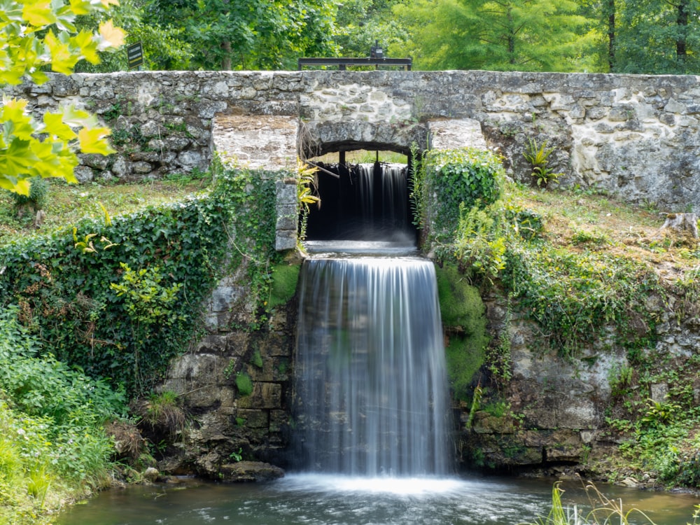 a waterfall in a stone tunnel