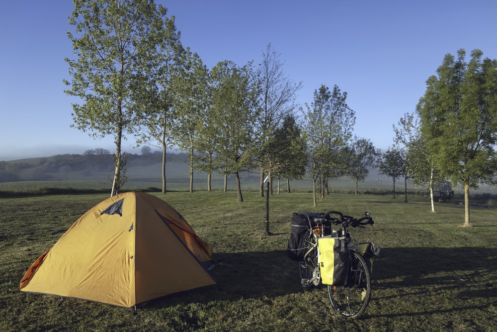 a tent and a bicycle in a field