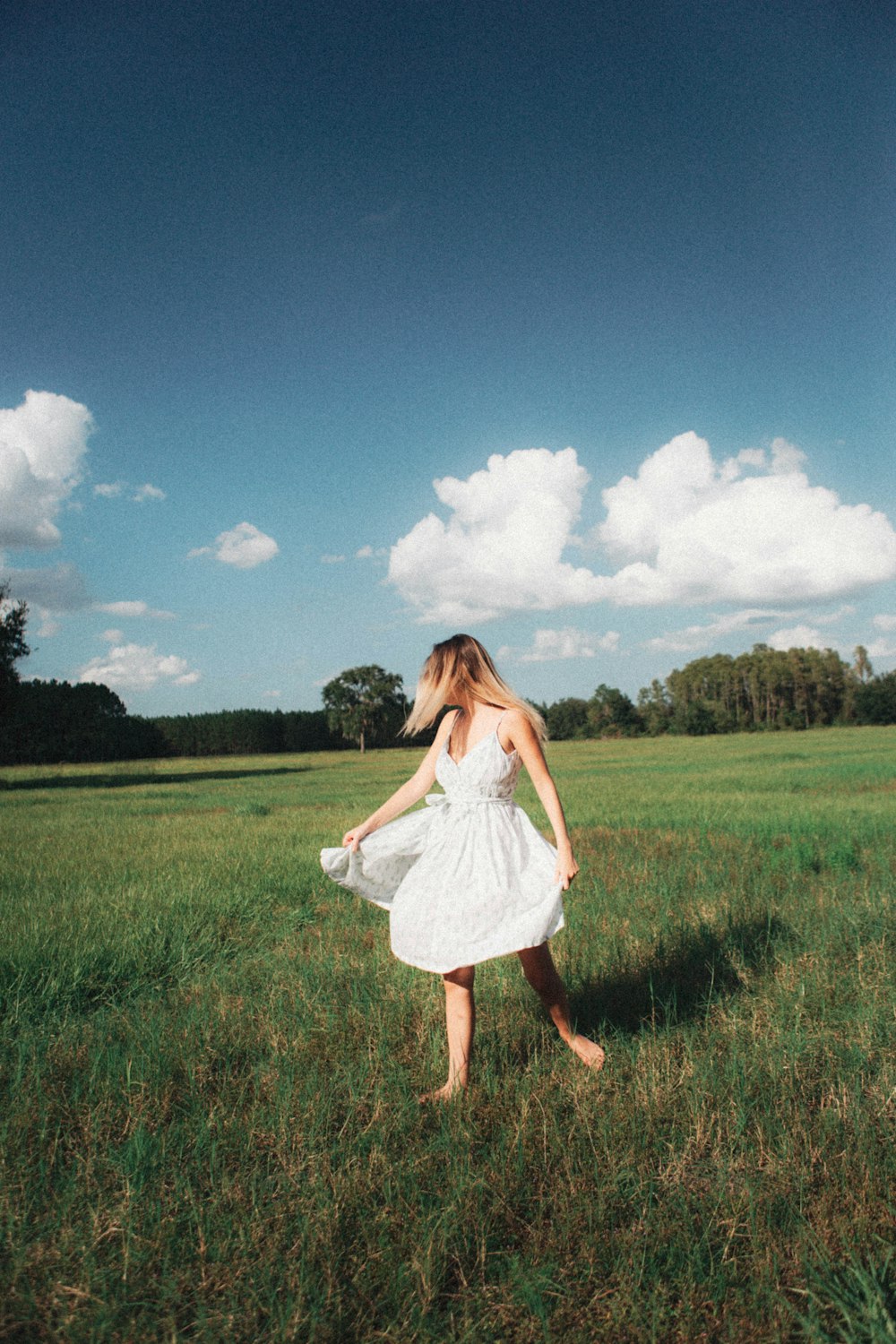 a person in a white dress walking in a field