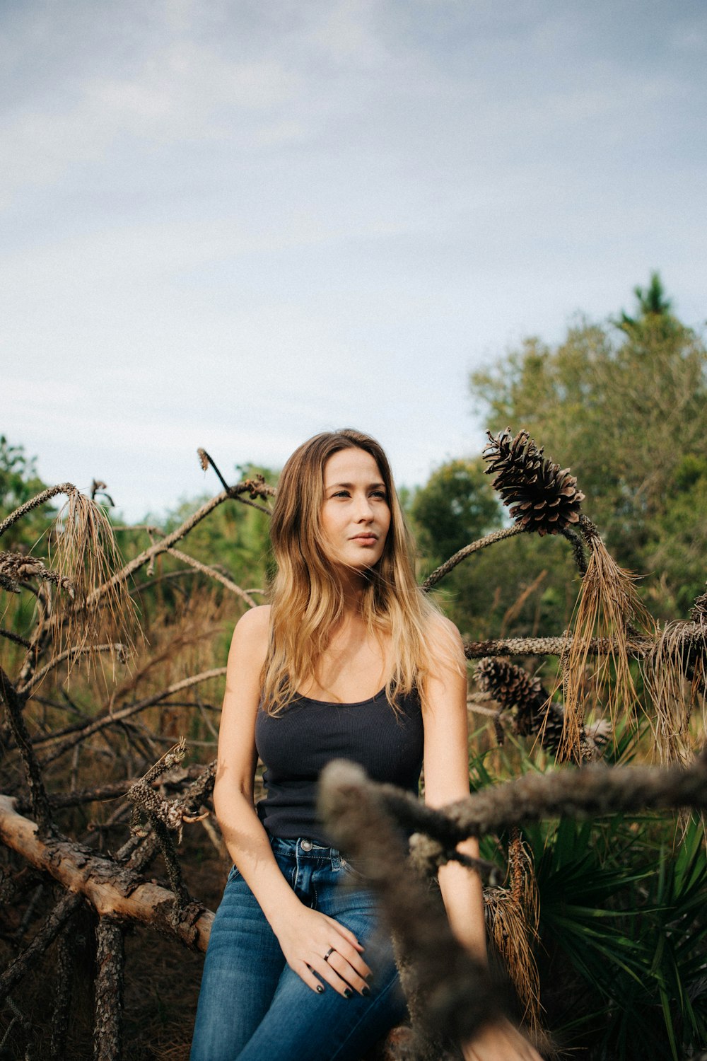 a woman sitting on a tree branch