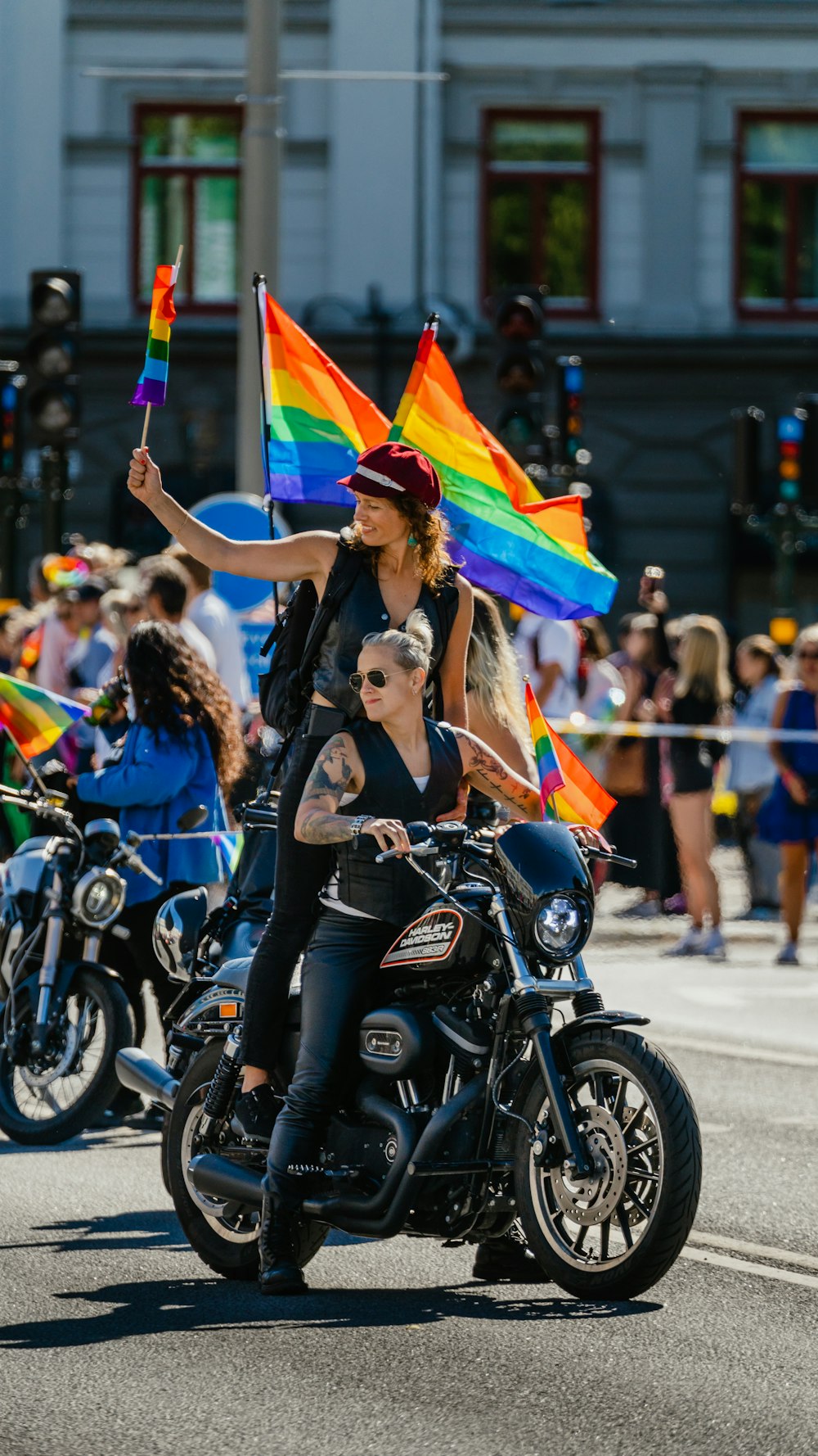 a couple of women riding a motorcycle with flags