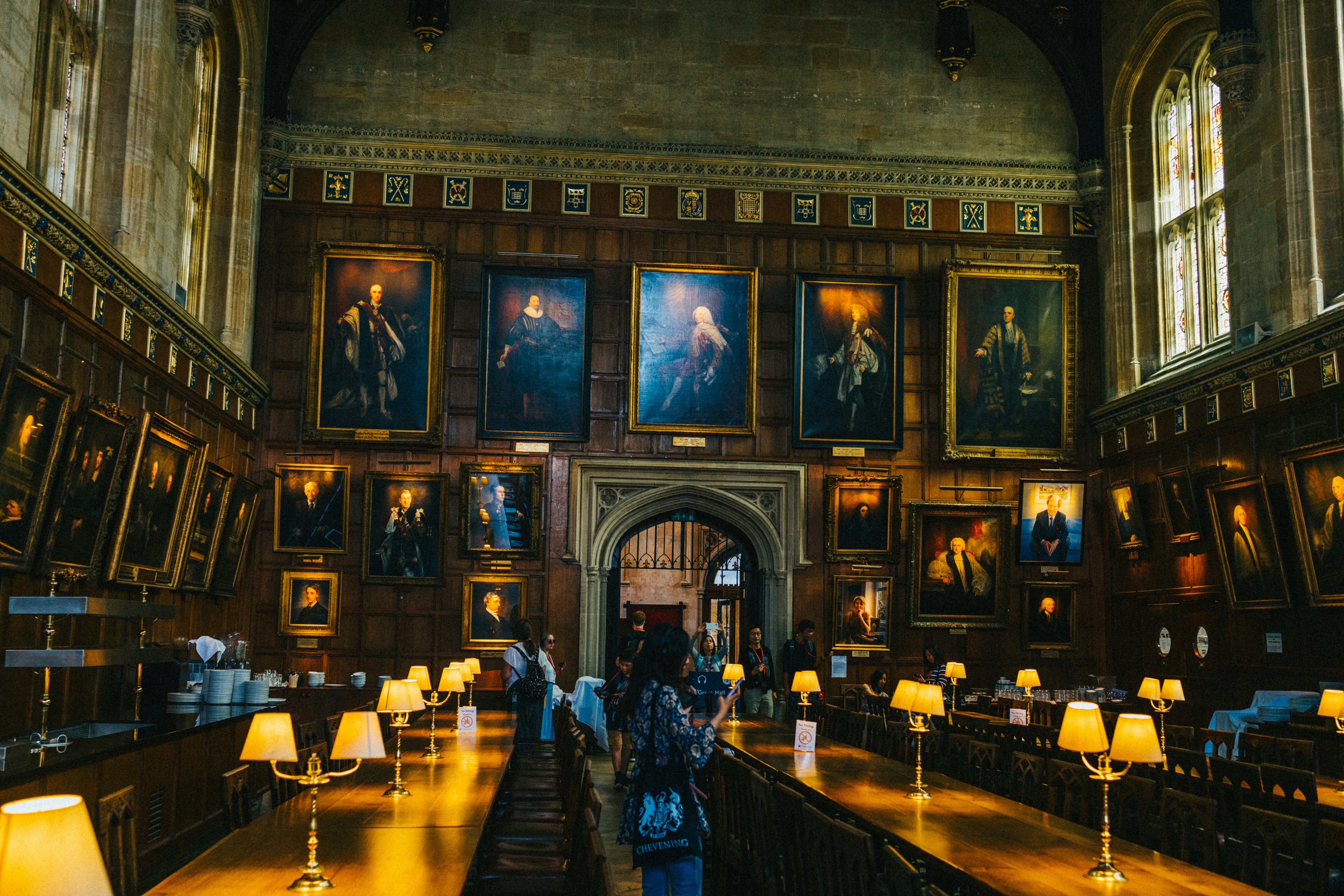 uma sala com muitas pinturas nas paredes e mesas