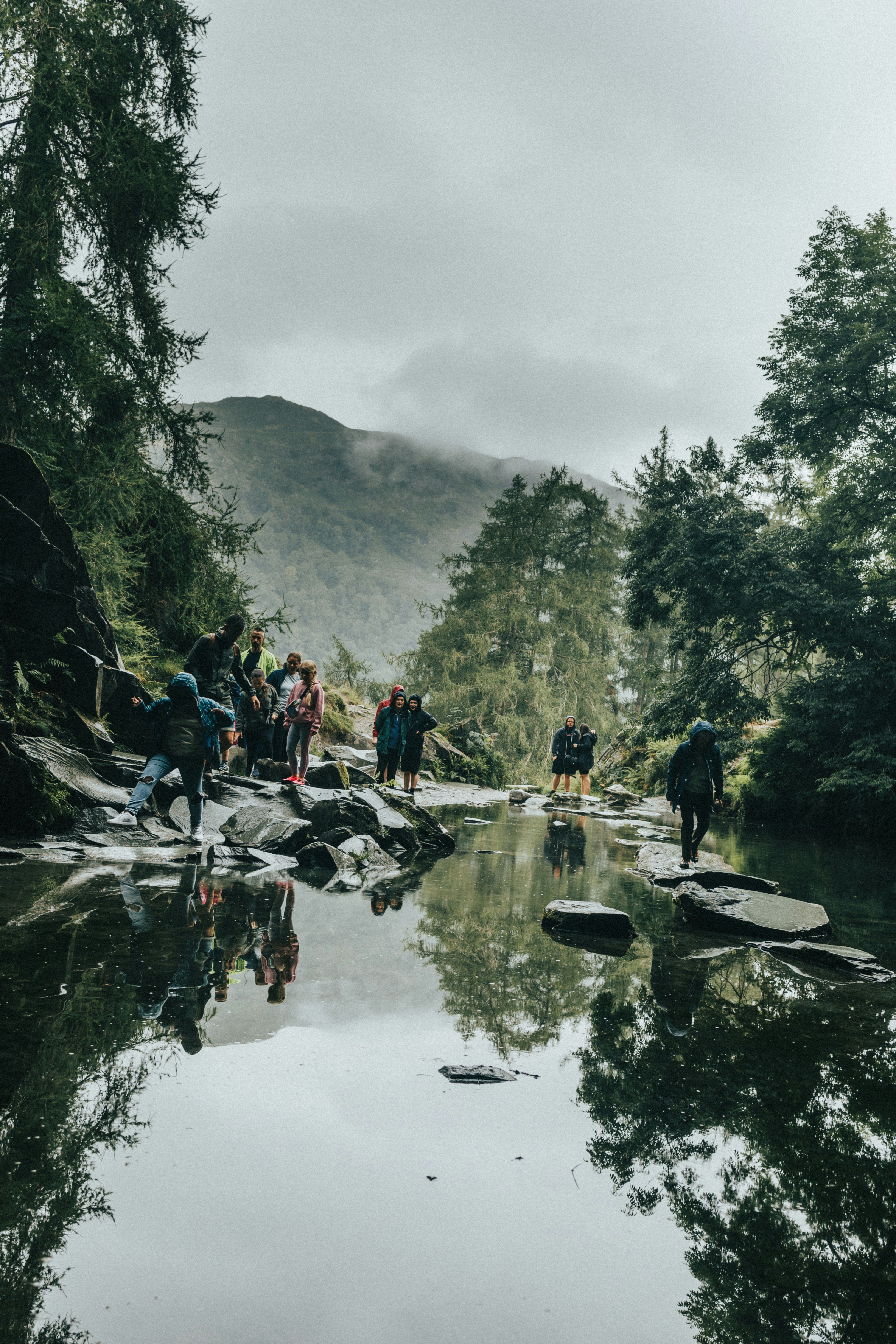 Un grupo de personas de pie sobre rocas junto a un río foto – Imagen de ...
