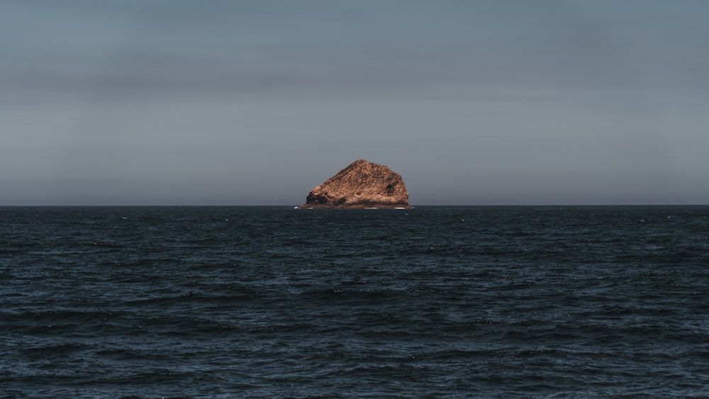 a large rock in the middle of the ocean