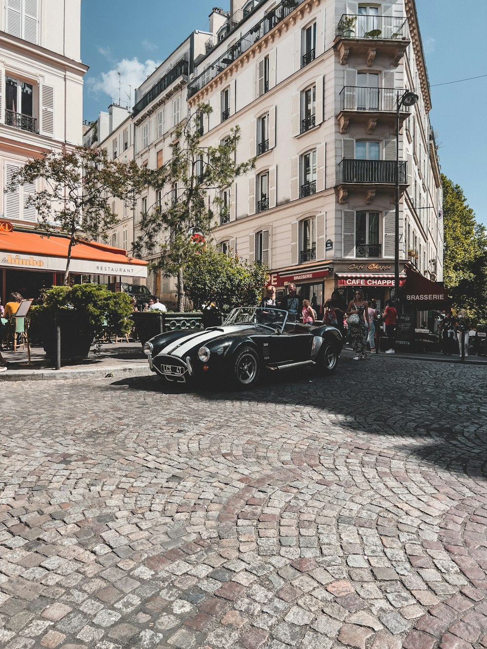 a car parked on a cobblestone street in front of a building