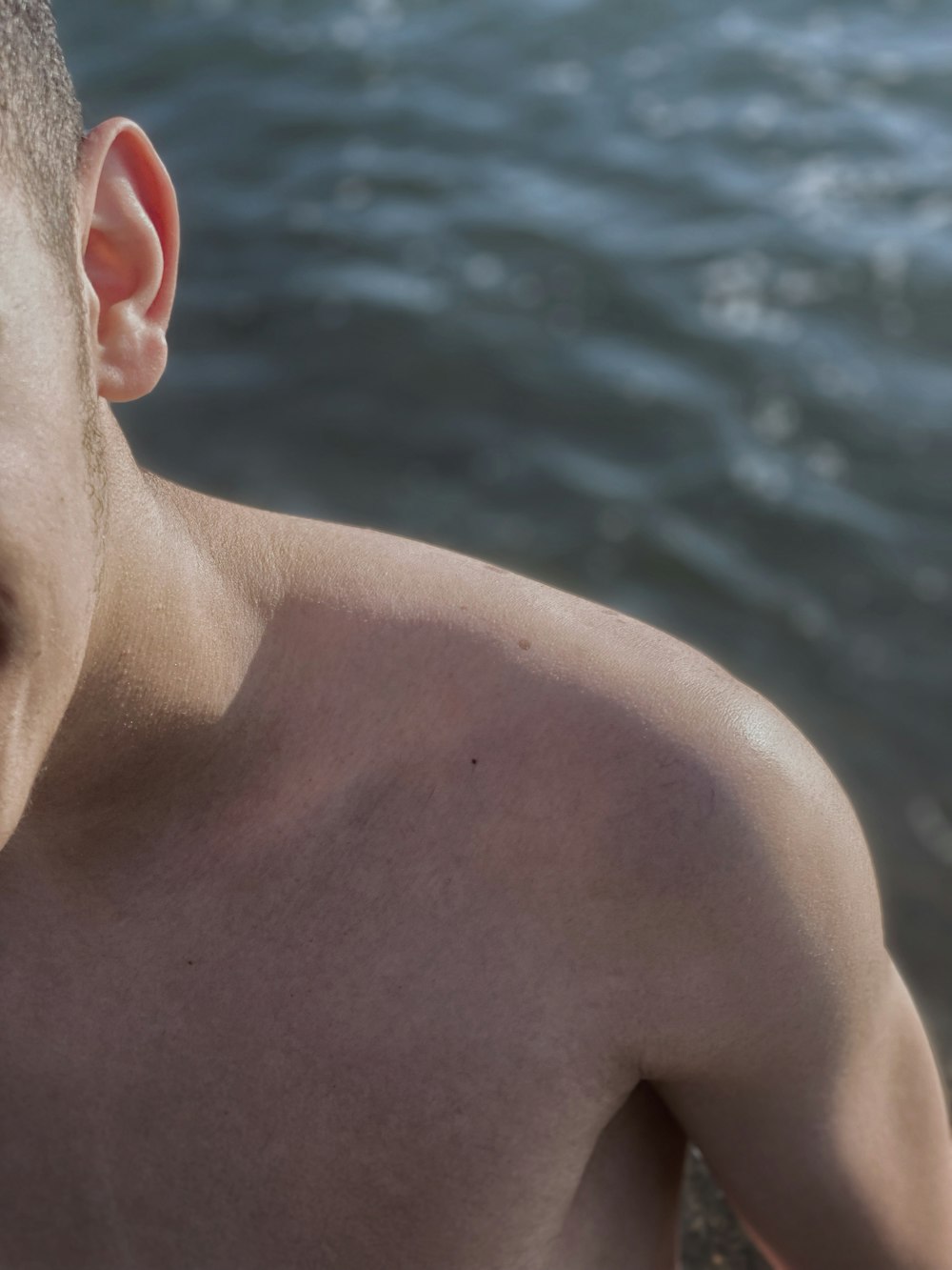 a person's back with a body of water in the background