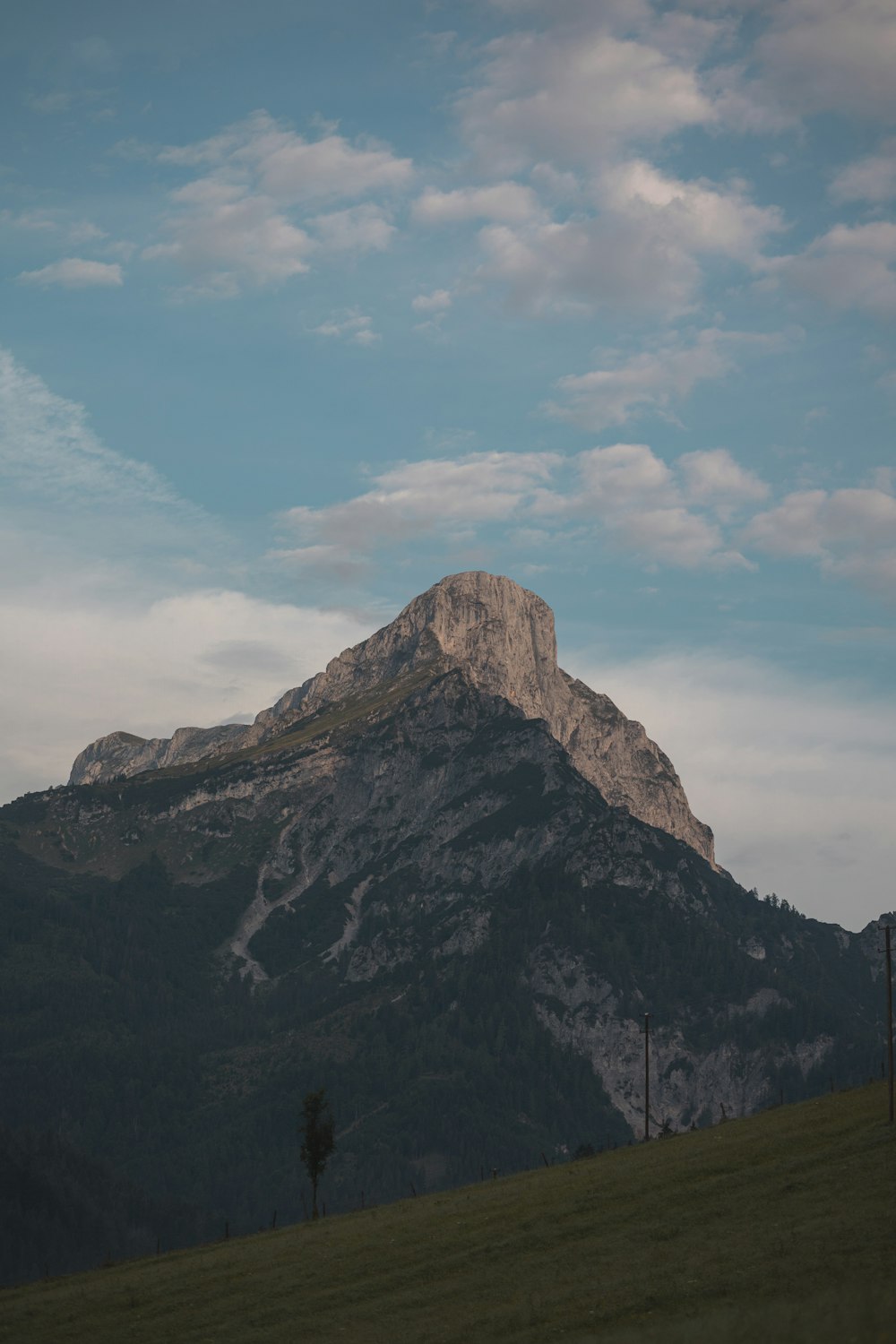 una montagna con un campo erboso sottostante