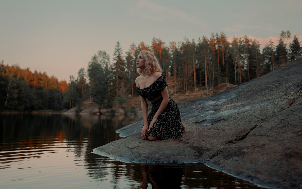 a man sitting on a rock in a lake