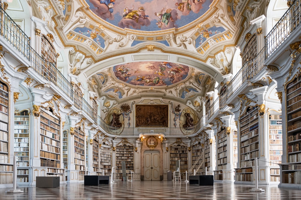 a large ornate room with a large ceiling and many bookshelves