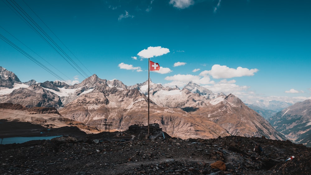 a flag on a pole in front of a mountain range