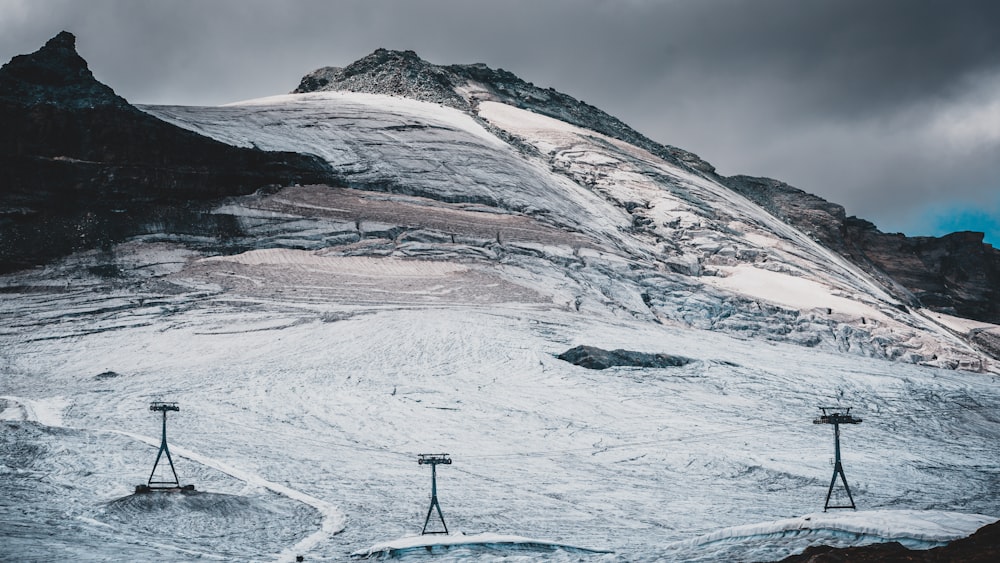 a snowy mountain with a few chairs