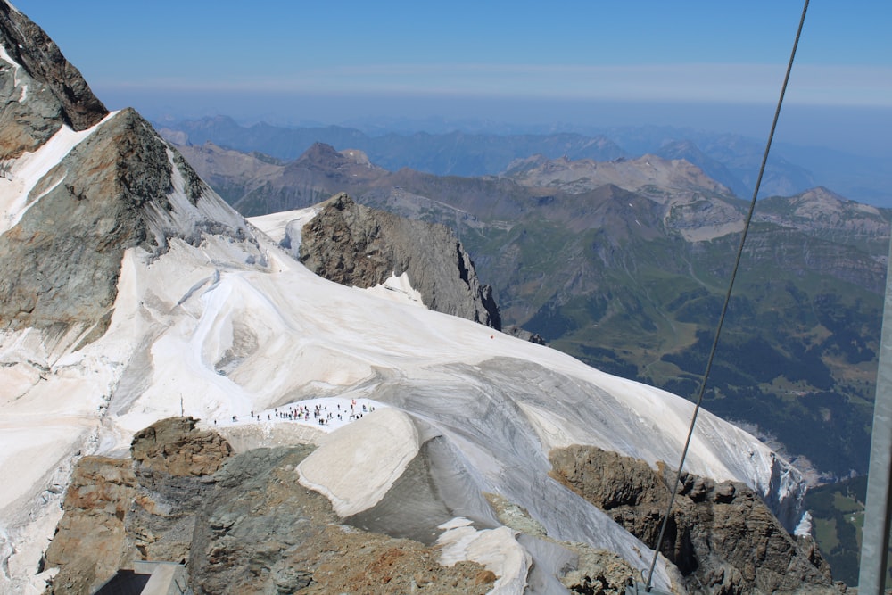 a snowy mountain with a valley below