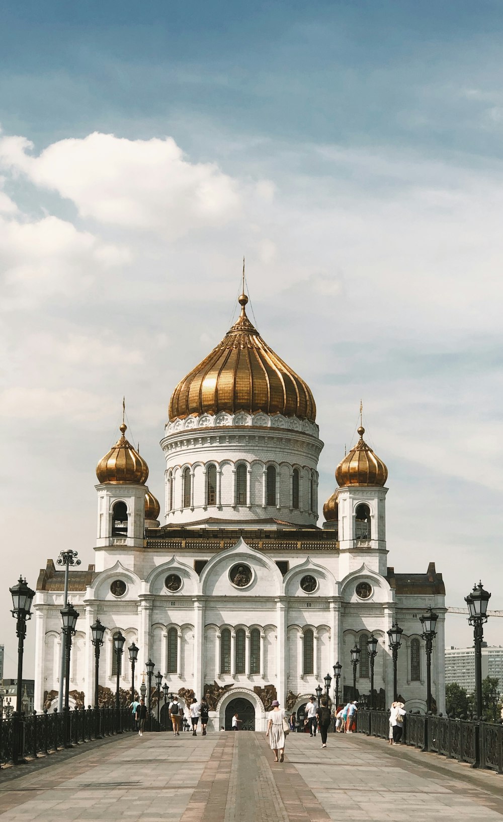 a large white building with a domed roof and a gold domed roof with Cathedral of Christ the Saviour in the background