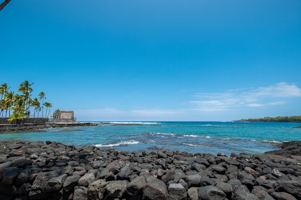 a rocky beach with a building on the shore