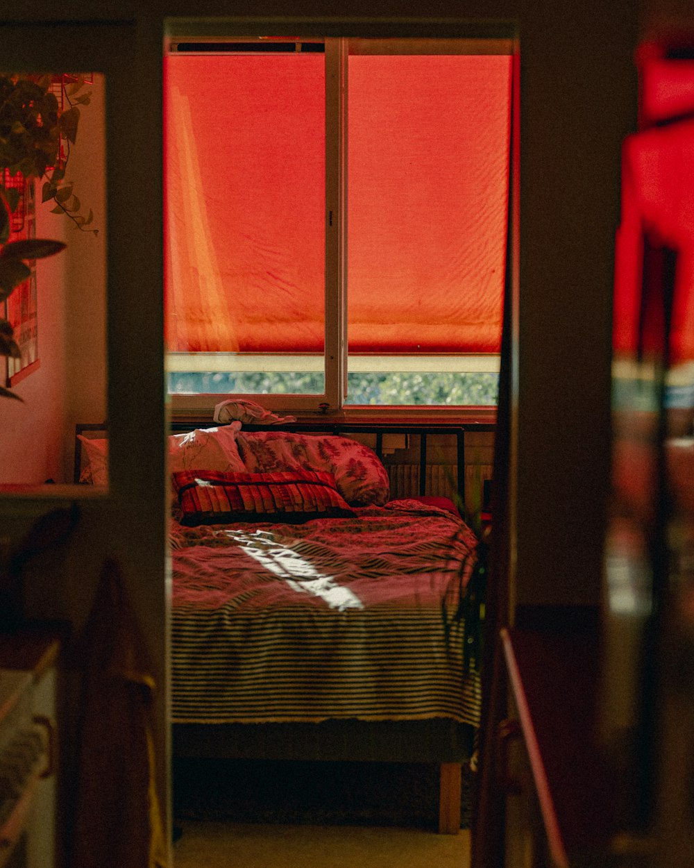 a small bedroom with a red bed