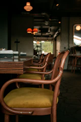 Interior view of a softly lit café lounge with comfortable chairs and wooden accents.