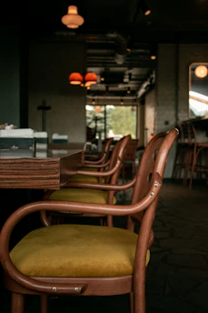 Interior view of a softly lit café lounge with comfortable chairs and wooden accents.