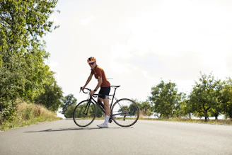 A cyclist pausing to enjoy the view during a cycle trip on a country road.