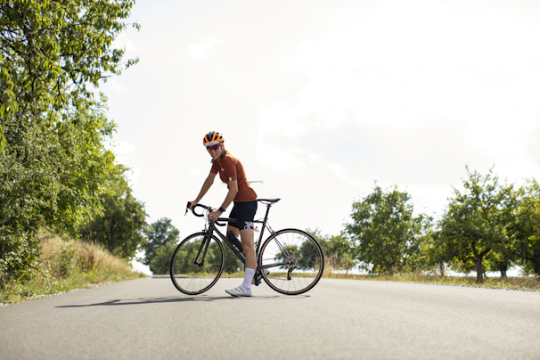 A cyclist pausing to enjoy the view during a cycle trip on a country road.