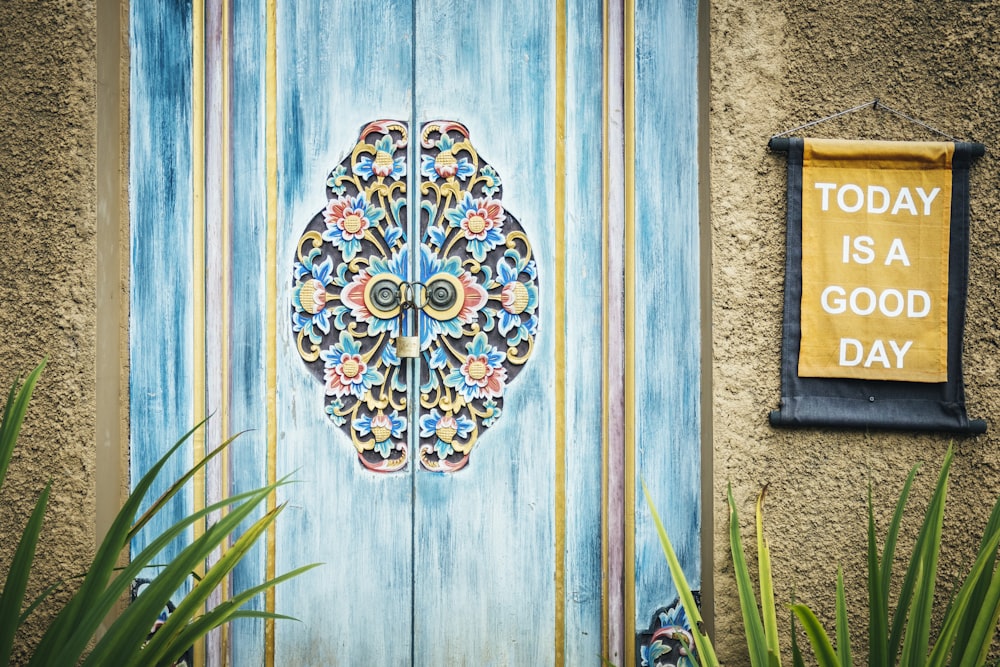 a sign next to a wall with a flower design