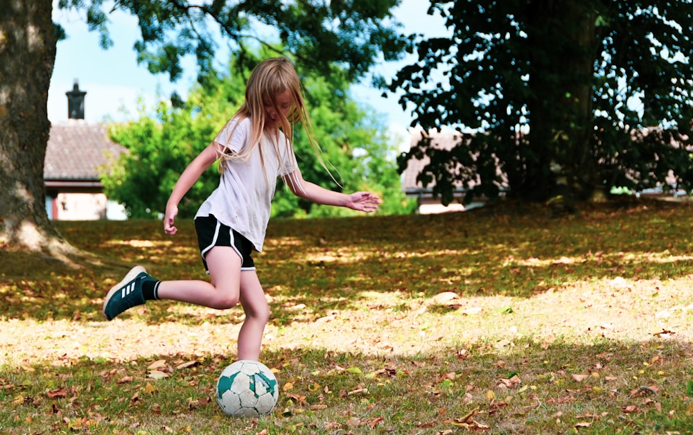 a girl kicking a football ball